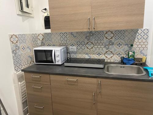 - un comptoir de cuisine avec un four micro-ondes et un évier dans l'établissement Pindemonte Suites, à Palerme