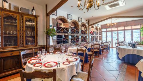 uma sala de jantar com mesas e toalhas de mesa brancas em Hostal El Puerto em Caleta de Velez