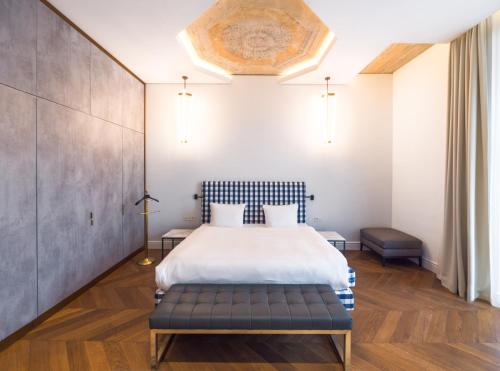 a bedroom with a bed with a bench in it at Hotel Pacai, Vilnius, a Member of Design Hotels in Vilnius