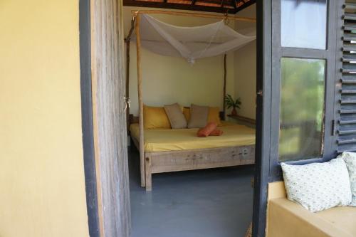 a bedroom with a bed with a canopy at Hilltop Cabanas in Komari