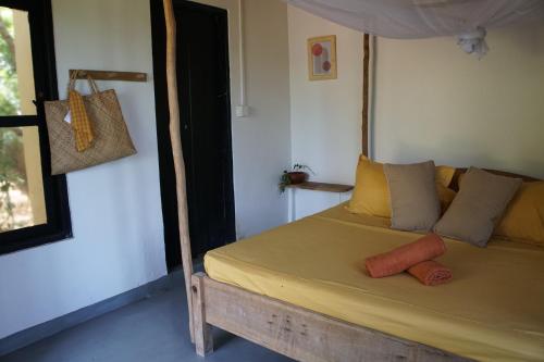 a bedroom with a bed with a wooden frame at Hilltop Cabanas in Komari
