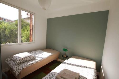 2 camas en una habitación con ventana en Maison avec piscine, sauna pour 8/10 personnes, en Romainville