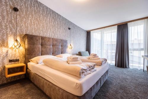 a bedroom with a large bed with a large window at Zillertal Suites Fügen by ALPS RESORTS in Fügen