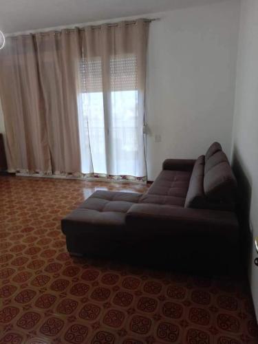 un sofá en una sala de estar con ventana en Casa Malu', en Galatone