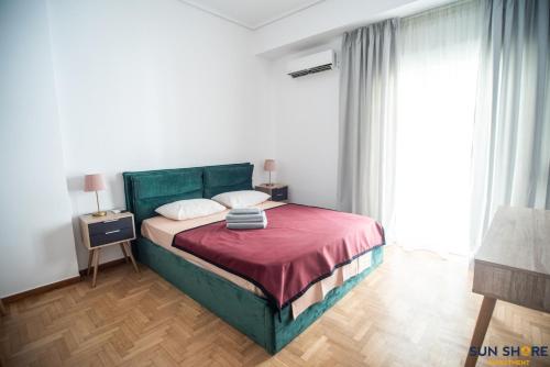 1 dormitorio con cama verde y manta roja en Explore Greece from City Centre Apartment, en Chalkida