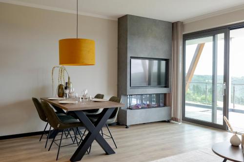 a dining room with a table and chairs and a television at Weitblick Winterberg in Winterberg