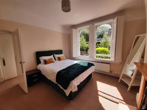 a bedroom with a bed and two windows at Wokingham - Central 2 beds home with parking in Wokingham