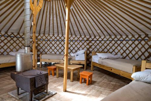 a room with beds and a stove in a yurt at Khun Odod Resort, Khuvsgul province Mongolia 