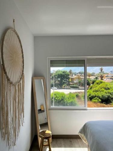 a bedroom with a bed and a window and a mirror at NIEUW: Bello Horizonte, house by the sea in Torremolinos