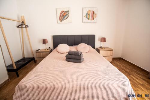 a bedroom with a bed with pink pillows on it at Explore Greece from Comfortable City Centre Apartment in Chalkida