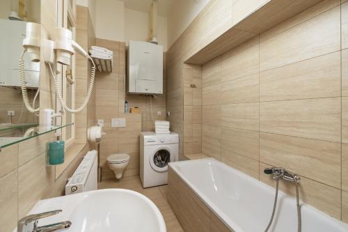 a bathroom with a sink and a washing machine at Unesco Prague Apartments in Prague