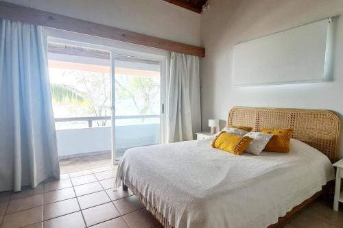 1 dormitorio con cama y ventana grande en Bastide sur Mer, en Blue Bay
