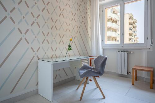 Cette chambre dispose d'un bureau et d'une chaise. dans l'établissement Kalbia Apartment Renovated, functional, intimate and more, à Cagliari