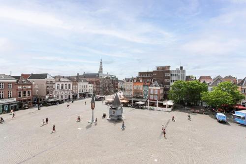 a group of people walking around a plaza in a city at Golden Tulip Hotel Central in Den Bosch
