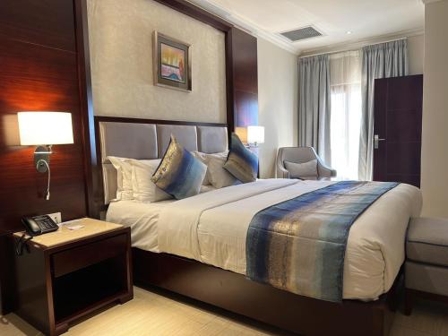 a hotel room with a large bed and a window at Grand Palace Hotel Lusaka in Lusaka