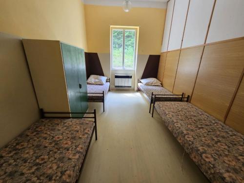 a room with three beds in a room with a window at Dobrá Voda u Záblatí - lesní areál in Záblatí