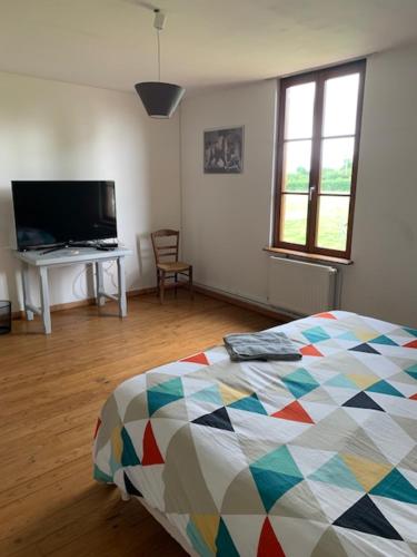 une chambre avec un lit et un bureau avec une télévision dans l'établissement Chambres d'hôtes, à Beaubec-la-Rosière