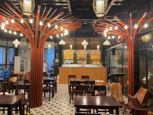 een restaurant met tafels en stoelen en grote sinaasappelbomen bij Phước Hưng Tam Cốc Homestay in Ninh Binh