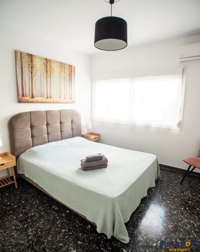 a bedroom with a bed and a large window at Explore Greece from Apartment with Private Garden in Chalkida