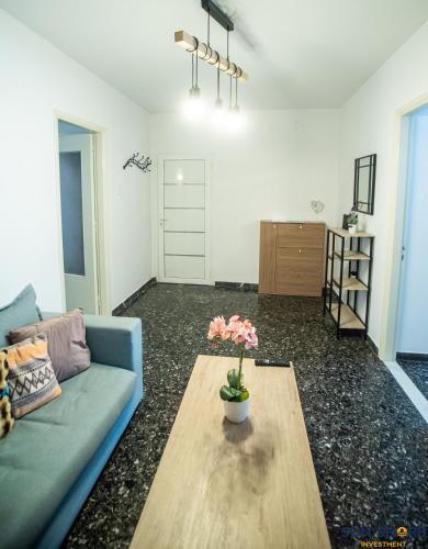 a living room with a blue couch and a coffee table at Explore Greece from Apartment with Private Garden in Chalkida