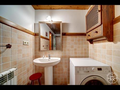 a bathroom with a washing machine and a sink at BARICAUBA de Alma de Nieve in Bagergue