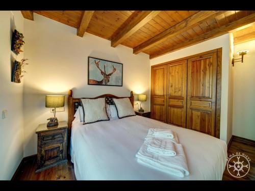 a bedroom with a bed with two towels on it at BARICAUBA de Alma de Nieve in Bagergue