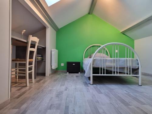 ein Schlafzimmer mit einer grünen Wand und einem Bett in der Unterkunft Fontaine Vieille in Saint-Georges-de-Luzençon