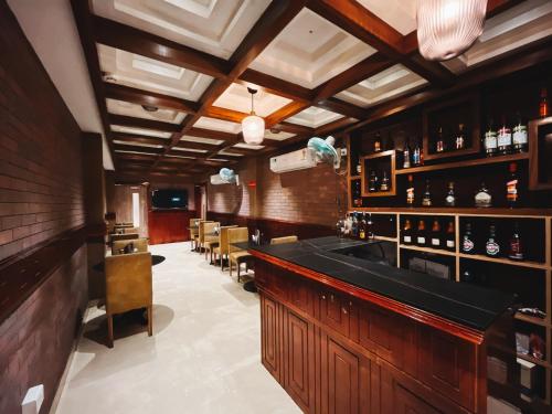 un bar con barra y sillas en una habitación en TGS Dine Inn en Port Blair