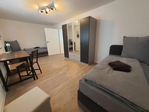 een slaapkamer met een bed, een tafel en een bureau bij ADAM Gästehaus in Sülzetal