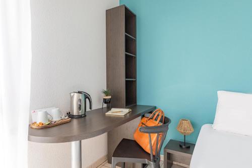 a small desk in a room with a bed at Appart'City Classic Toulouse Tournefeuille in Tournefeuille