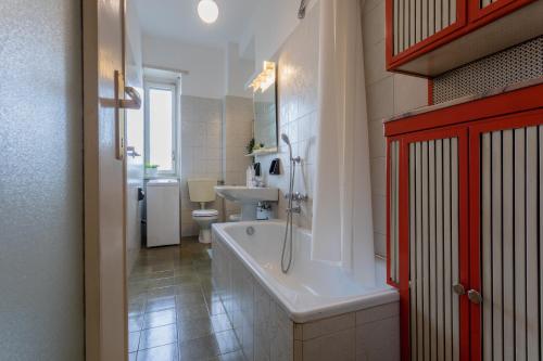 łazienka z wanną, toaletą i umywalką w obiekcie Little Peschiera by Wonderful Italy w Turynie