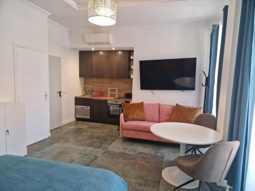 un salon avec un canapé rose et une table dans l'établissement City Center Boutique Studio Nr 2, à Nice