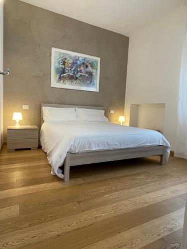 a bedroom with a large white bed with two lamps at Sarah Apartment Verona Fiera in Verona