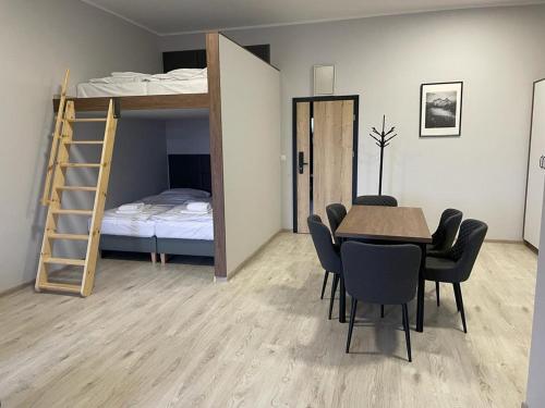 a dining room with a table and a bunk bed at Apartamenty Delux-S1 przy trasie S1 in Łodygowice