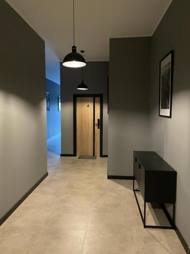 a hallway with a black table and a door at Apartamenty Delux-S1 przy trasie S1 in Łodygowice