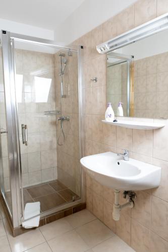 a bathroom with a shower and a sink at Liszt Apartman in Pécs