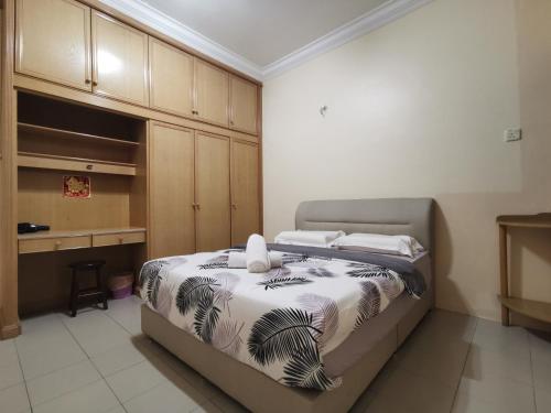 a bedroom with a bed and a desk and cabinets at DIY Palm Court Bedroom in Kuantan