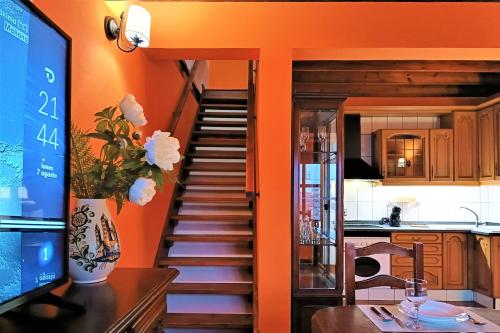 una escalera en una cocina con paredes de color naranja en Casa La Molina- A, en Triquivijate