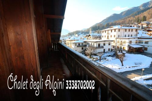 a balcony with a view of a town in the snow at Chalet Degli Alpini in Pieve di Cadore