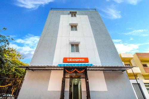 un edificio blanco alto con un letrero. en FabExpress Diamond Residency, en Pune