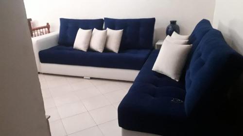 a blue couch with white pillows in a living room at Résidence riad Hay riad in Ifrane
