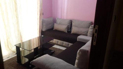 un soggiorno con divano e tavolo in vetro di Résidence riad Hay riad a Ifrane