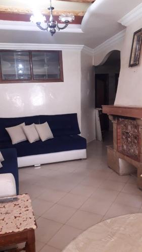 un soggiorno con divano blu e camino di Résidence riad Hay riad a Ifrane