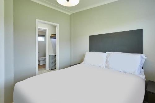 a bedroom with a white bed and a mirror at Host & Stay - 19 The Pines in Runswick