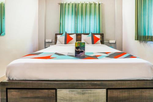 a bedroom with a large bed with colorful sheets at FabExpress Diamond Residency - Airport road in Pune