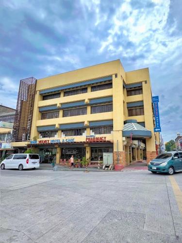 a large building with cars parked in front of it at Blue Velvet Hotel -CM Recto in Davao City