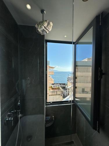 a bathroom with a shower with a view of the ocean at Villa Idrizi in Sarandë