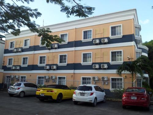 a building with cars parked in a parking lot at Capital Hotel in Garapan