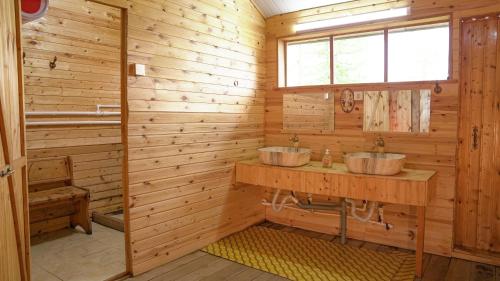 two sinks in a wooden bathroom with a window at Nature Door Resort, Khuvsgul province, Mongolia 