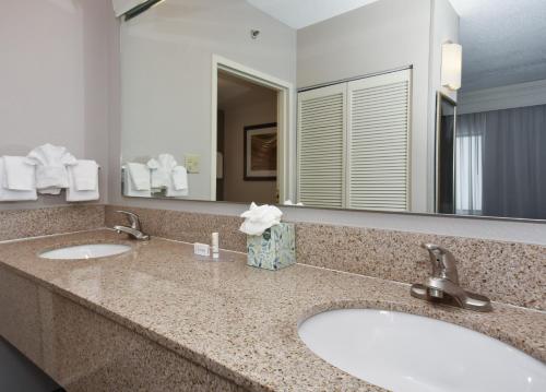 a bathroom with two sinks and a large mirror at Courtyard by Marriott Charlotte Matthews in Matthews